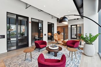 A living room with red chairs and a table